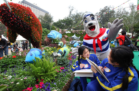 Photo 1: Ocean Park mascot Whiskers poses next to the giant panda display