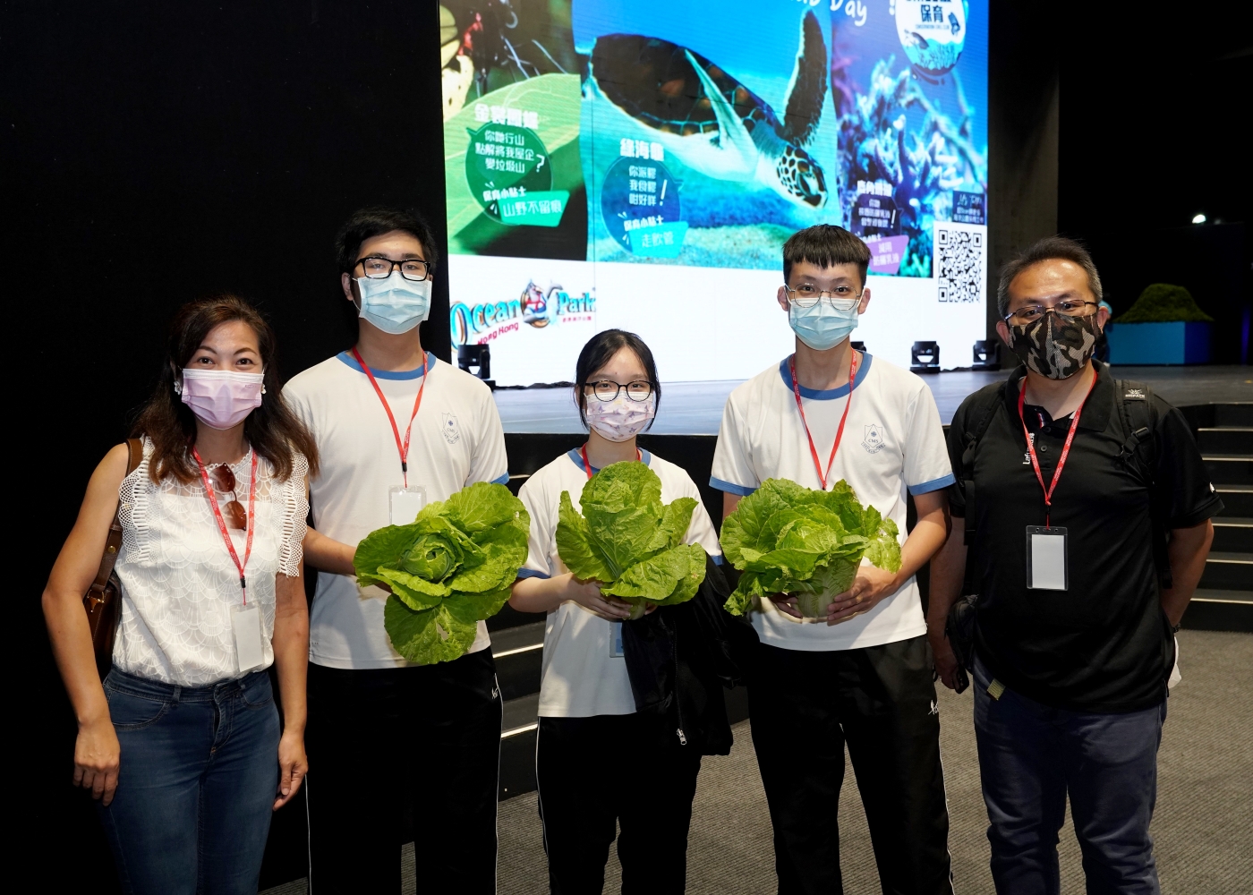 Students with vegetables especially grown for rescued green turtles
